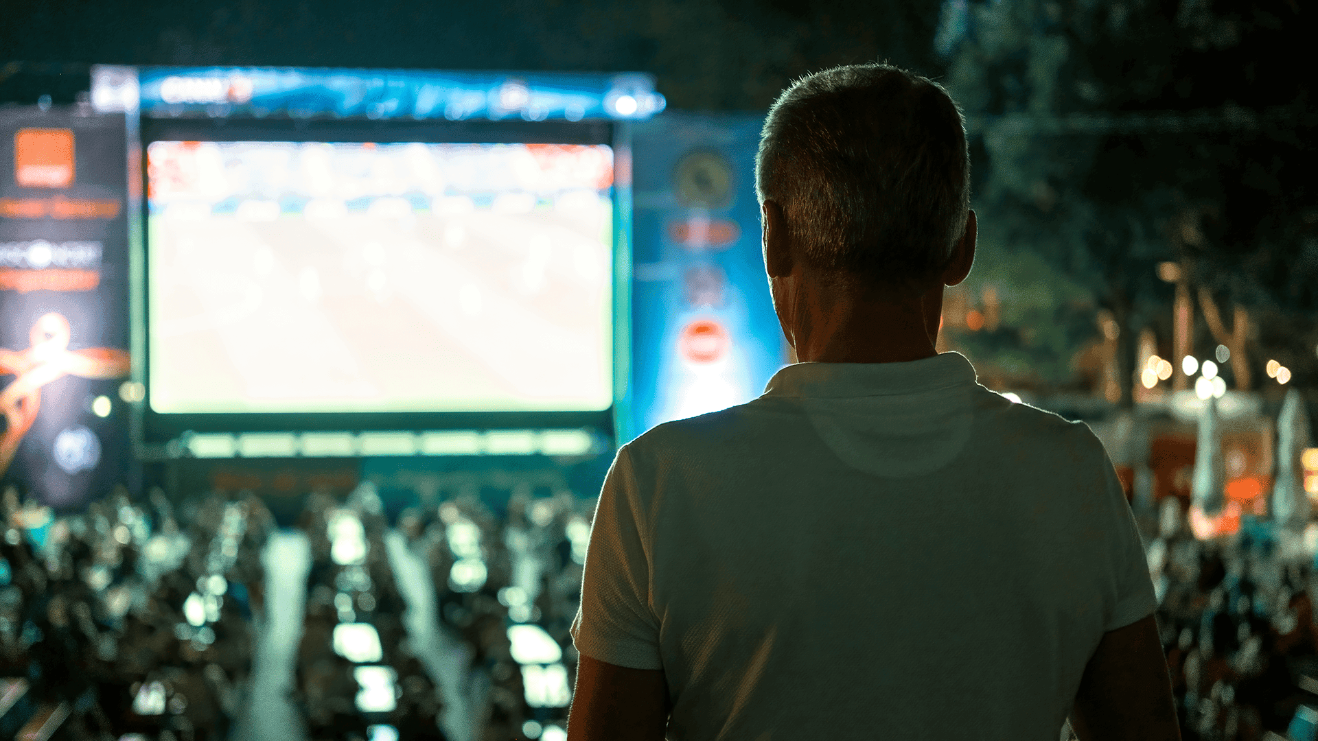 sitting-man-watching-football-public-place-night.png